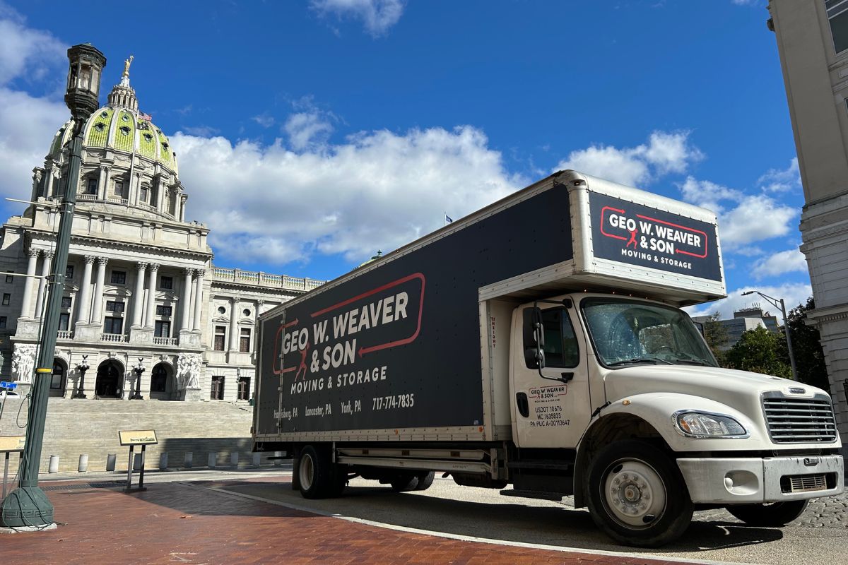 A photo of a Geo W Weaver and Son Moving Truck in front of the State Capital and in the process of helping a local business with an office move